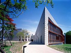 the building is shaped like a triangle with many windows on each side, and has red trim around the edges