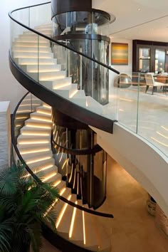 a spiral staircase with glass railings in a house