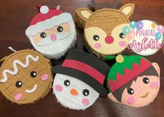 four decorated cupcakes sitting on top of a wooden table