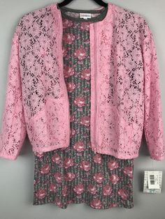 a pink cardigan sweater and dress on a hanger