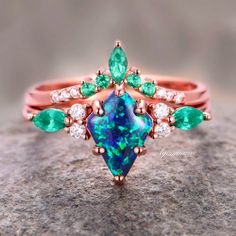 Indulge in the timeless elegance of our Skye Blue Fire Opal & Emerald Ring Set, crafted exclusively for women seeking sophistication and allure. Delicately encased in luxurious 14K rose gold vermeil, this engagement ring radiates with ethereal beauty.►The centerpiece features a captivating Skye Blue Fire Opal, renowned for its mesmerizing play of colors reminiscent of the sky at dawn. Enhanced by the vibrant allure of emeralds, each gemstone exudes a natural brilliance, symbolizing growth, renew Elegant Rose Gold Emerald Ring In 14k, Elegant 14k Rose Gold Emerald Ring, Elegant Emerald Rose Gold Rings, Formal Multi-stone Rose Gold Jewelry, Elegant Rose Gold Emerald Ring For May Birthstone, Elegant Rose Gold Ring With Emerald, Formal Rose Gold Multi-stone Jewelry, Elegant Rose Gold Emerald Rings, Formal Rose Gold Emerald Jewelry