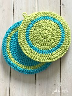 two crocheted coasters sitting on top of a white wooden floor next to each other