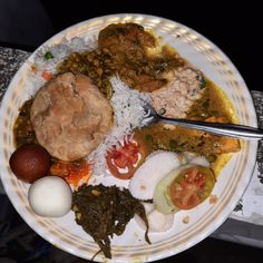 a white plate topped with lots of different types of food on top of a table