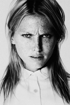 a black and white photo of a woman with freckles on her face