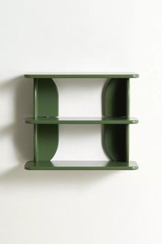 a green shelf sitting on top of a white wall