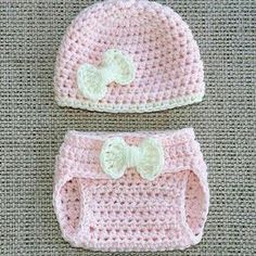 two crocheted hats and diaper covers sitting on top of a gray surface