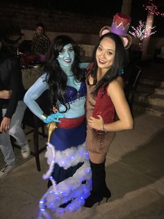 two women dressed up in costumes pose for the camera