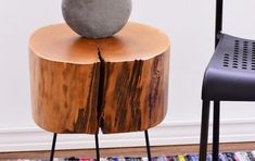 a wooden table with a black chair next to it and a gray vase on top