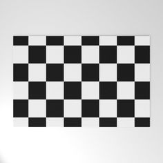 a black and white checkerboard pattern is hanging on the wall in an empty room