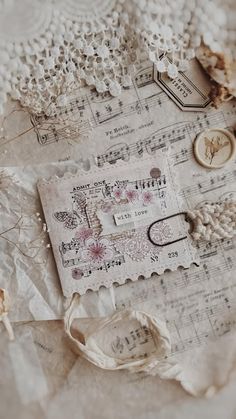 an old piece of paper with lace and buttons on it, surrounded by other items