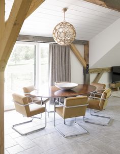 a dining room table with chairs and a chandelier hanging from the ceiling