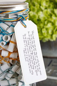 a jar filled with lots of white and blue items next to a green flower pot