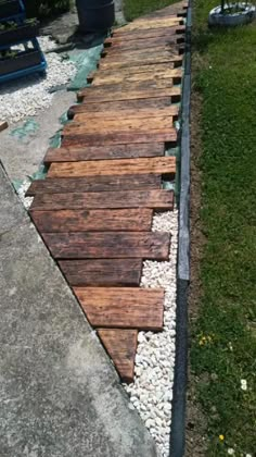 a walkway made out of wooden planks and gravel