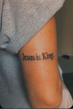 a person with a tattoo on their arm that says jesus is king