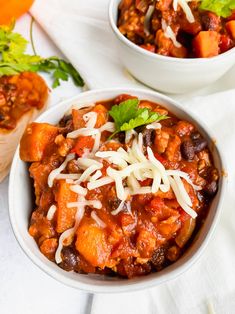 two white bowls filled with chili and cheese