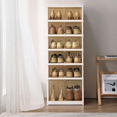 a white shelf filled with lots of shoes next to a wooden chair and window sill