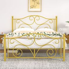 a yellow metal bed with white sheets and pillows