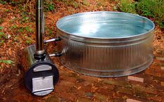 a large metal tub sitting on top of a brick walkway