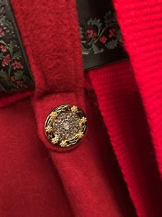 a red coat with a gold button on it