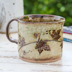 an old coffee cup sitting on top of a wooden table