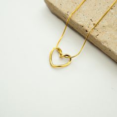 Enhance your elegance with our exquisite gold-colored necklace featuring a heart-shaped pendant. This stunning piece effortlessly combines simplicity with sophistication, making it a perfect accessory for any occasion. ✨ Unique Features: 🌟 Heartfelt Design: The pendant showcases a simple, open-heart design with smooth, rounded edges that symbolizes love and grace. 🌟 Elegant Chain: Comes with a fine, gold-colored snake chain that adds a touch of luxury to any outfit. 🌟 Versatile Charm: Perfect Minimalist Open Heart Necklace With Adjustable Chain, Minimalist Open Heart Necklace For Her, Minimalist Open Heart Necklace As Gift For Her, Minimalist Open Heart Necklace Gift For Her, Minimalist Gold Plated Heart Necklace For Everyday, Minimalist Double Heart Tarnish-resistant Necklaces, Minimalist Tarnish Resistant Double Heart Necklace, Minimalist Tarnish-resistant Double Heart Necklace, Minimalist Gold-plated Double Heart Necklace