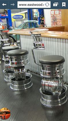 three chrome stools sitting next to each other on a wooden floor in front of a counter