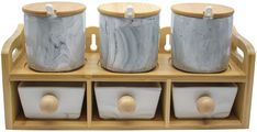 three white ceramic containers with wooden handles on a shelf in front of a white background