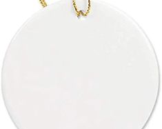 a white round ornament hanging from a gold chain