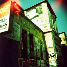 an old building with graffiti on it and a sign that says grill biss next to it