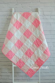 a pink and white quilt on a chair