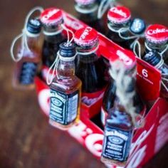 a bunch of soda bottles sitting in a red box on top of a wooden table