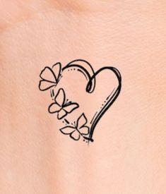 a small heart tattoo on the back of a woman's stomach, with flowers in it