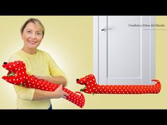 a woman holding two stuffed animals in front of an open door with polka dot fabric