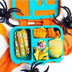 a lunch box with food in it and spider decorations