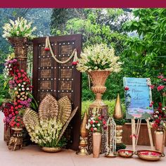 an assortment of vases and flowers are on display in front of a wooden door