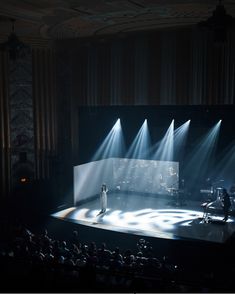 an empty stage with several spotlights on it and people standing in the middle watching