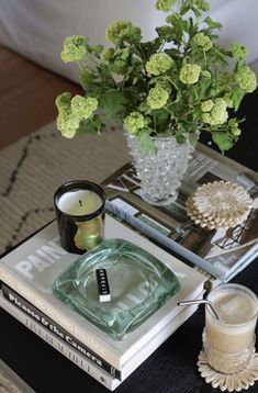 a glass vase filled with flowers sitting on top of a table next to two books