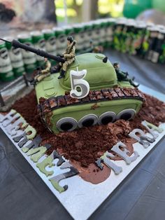 a birthday cake made to look like a tank with the number five on it and soldiers