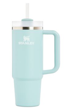 the stanley travel mug is light blue with a stainless steel lid and white insulated handle