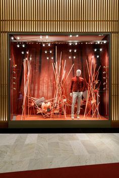 a display case in the shape of reeds with a mannequin standing next to it