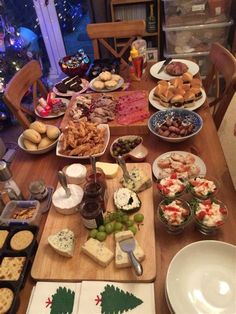 a wooden table topped with lots of different types of foods and desserts on plates