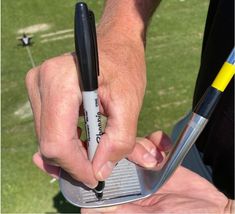 a man holding a golf club and ball marker