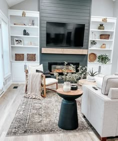 a living room with two couches and a television on top of a fireplace mantel