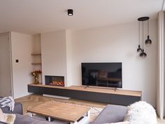 a living room with couches and a flat screen tv on top of a wooden table