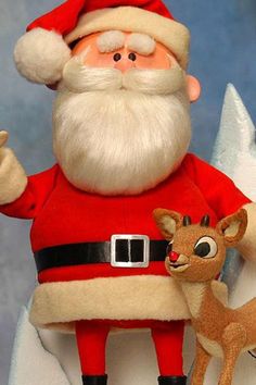 a santa clause holding a deer and pointing at it's left side with his right hand