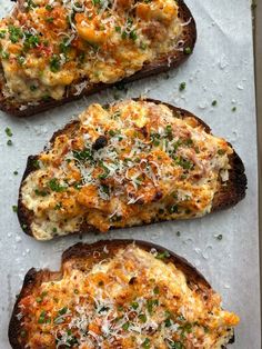 three pieces of bread topped with cheese and herbs