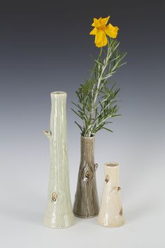 three vases with flowers in them on a table