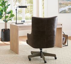 a brown office chair sitting on top of a rug in front of a wooden desk