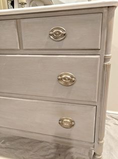 a white dresser with gold handles and knobs