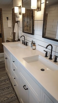 a bathroom with double sinks and two mirrors on the wall next to eachother